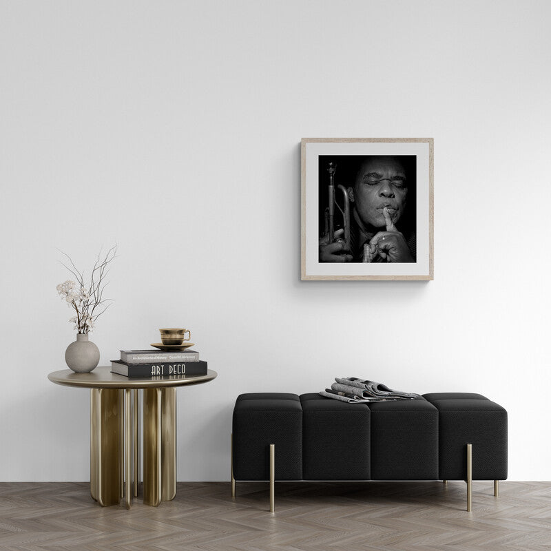 Modern living room with a black sofa, side table, and framed artwork on the wall.