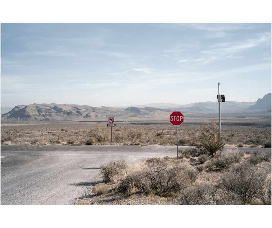 Landscape photography of a crossroad with a lone Stop sign in a desertic patch of the American West.