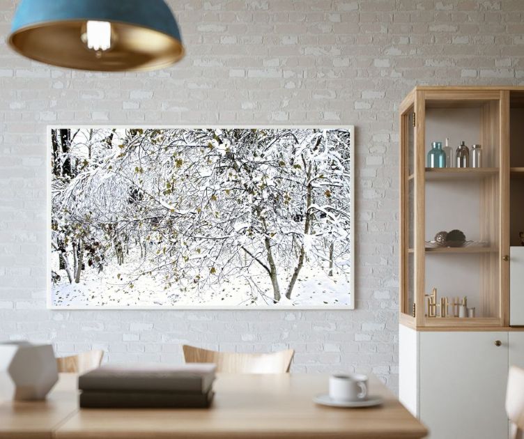 Dining room with a large print of snow-covered trees above a wooden table, with shelves nearby.