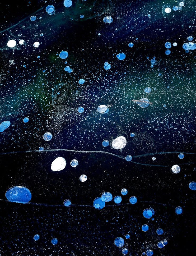 Artistic depiction of bubbles floating in water with a dark blue background
