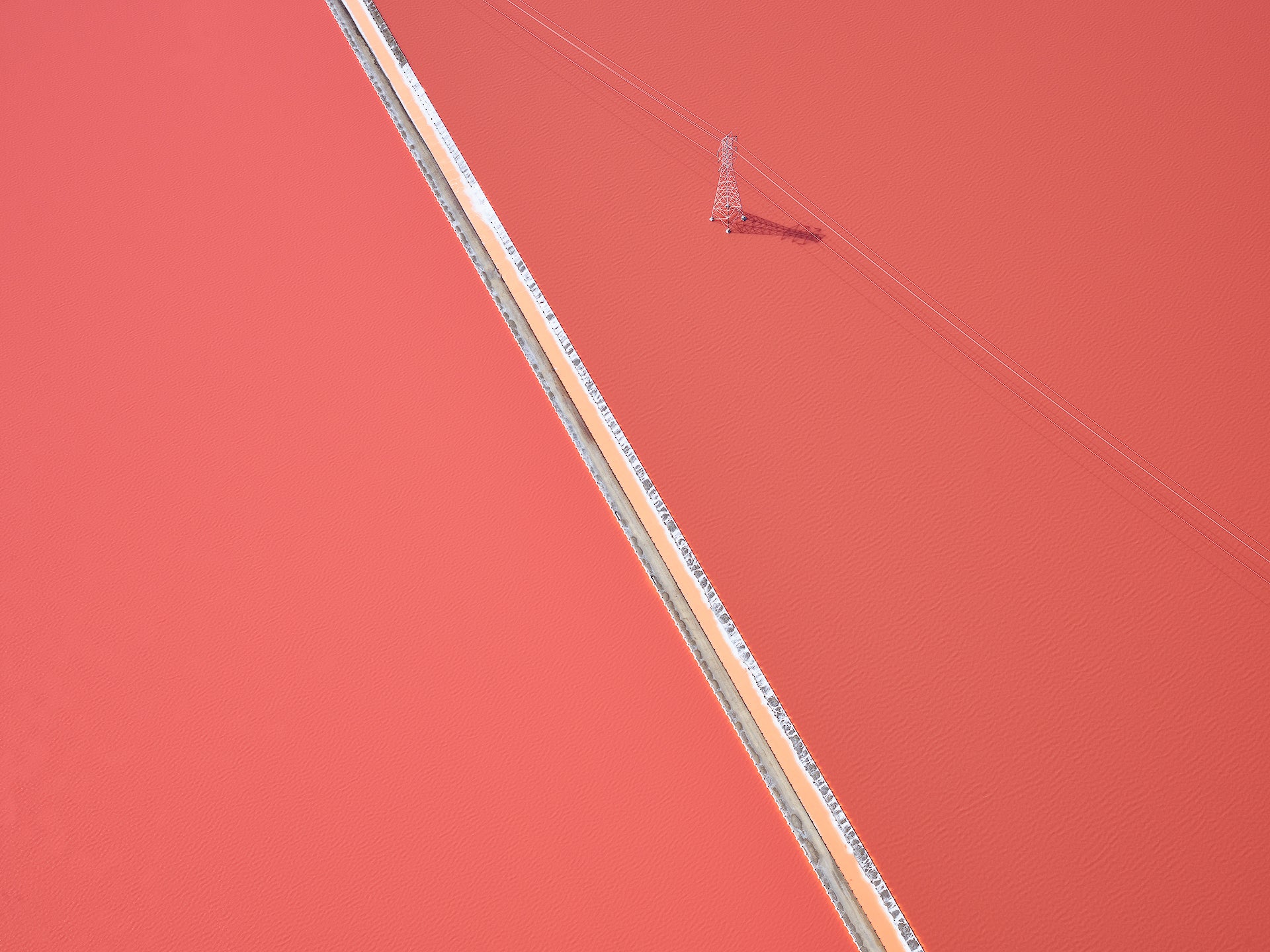 Aerial view of a straight road cutting through an orange landscape