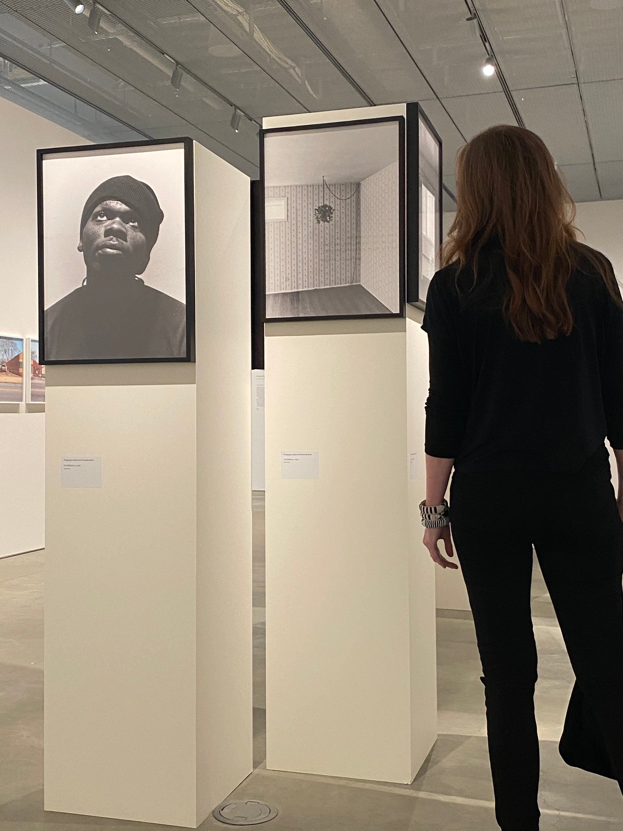 Person looking at a framed black and white portrait in a musuem setting
