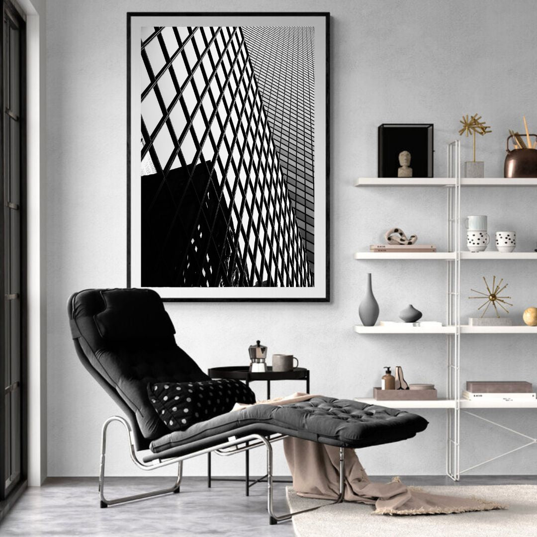 Modern living room with a black and white abstract art piece on the wall, a black armchair, and a white shelf.