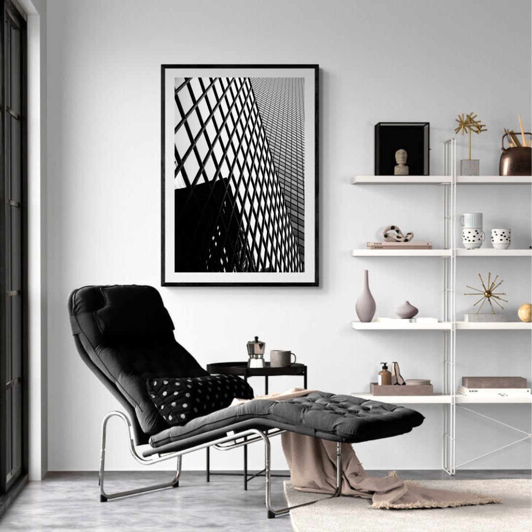 Modern living room with black armchair, abstract art, and shelves.