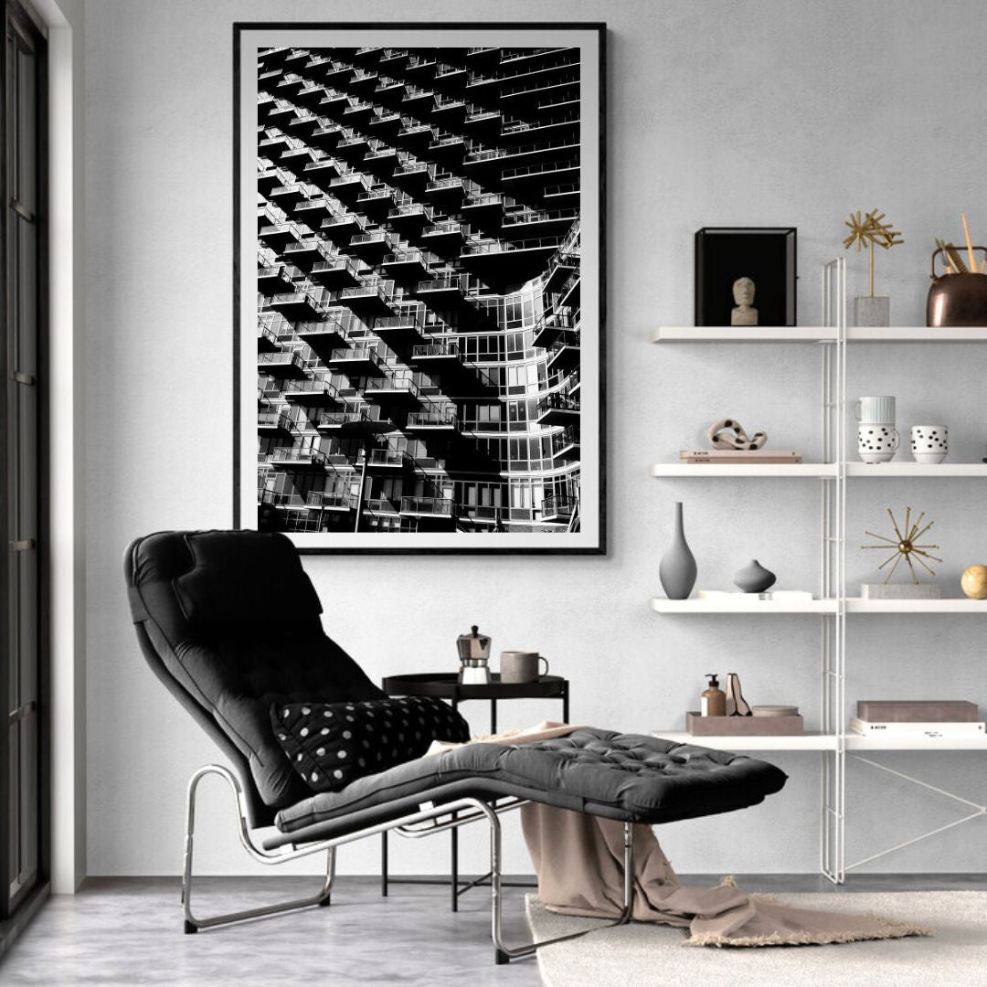Modern living room with a black armchair, abstract art, and shelves with decor items.