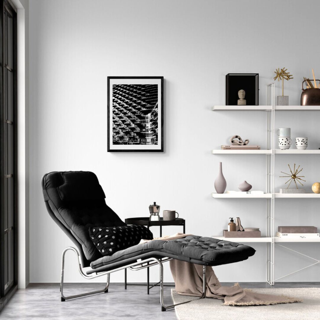 Modern living room with black armchair, white shelves, and framed artwork.