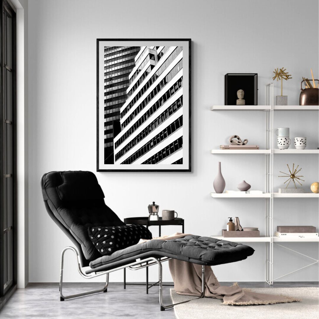Modern living room with a black armchair, ottoman, and abstract art on the wall.