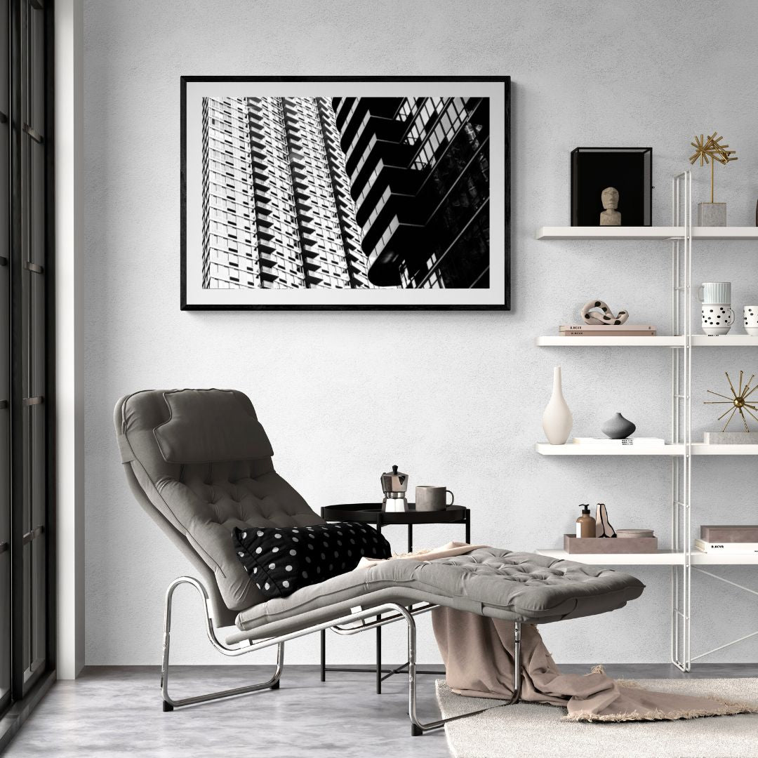 Modern living room with a gray armchair, ottoman, and abstract art on the wall.