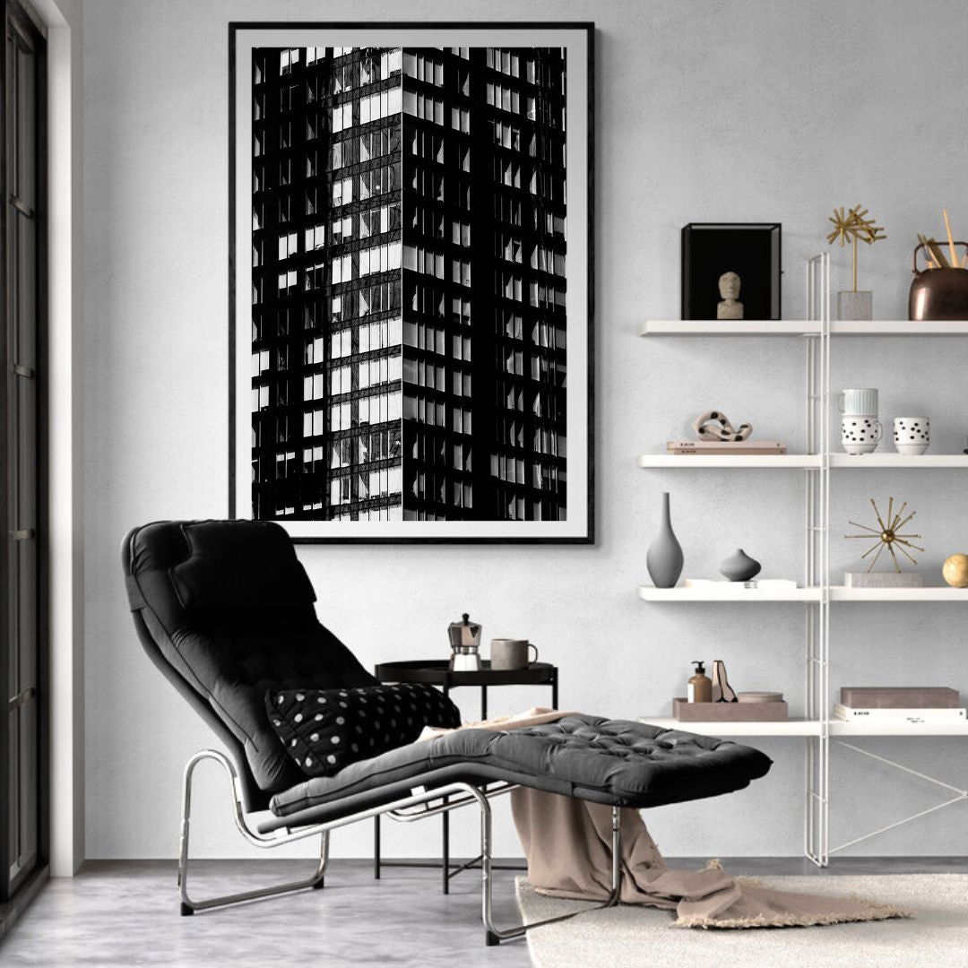 Modern living room with a black chair, white shelves, and a black and white framed artwork.
