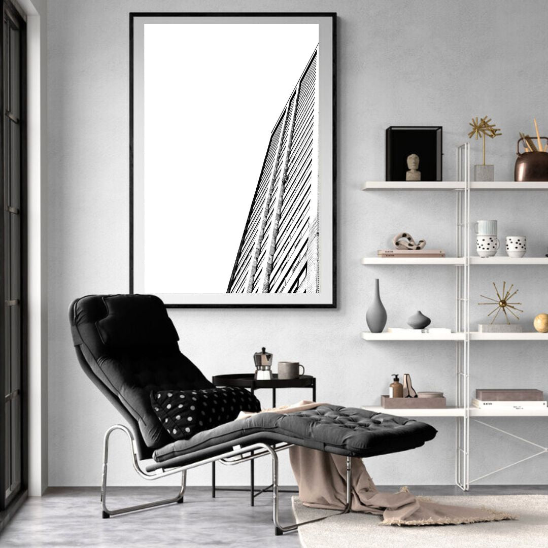 Modern living room with a black armchair, white shelves, and a framed black and white photo on the wall.