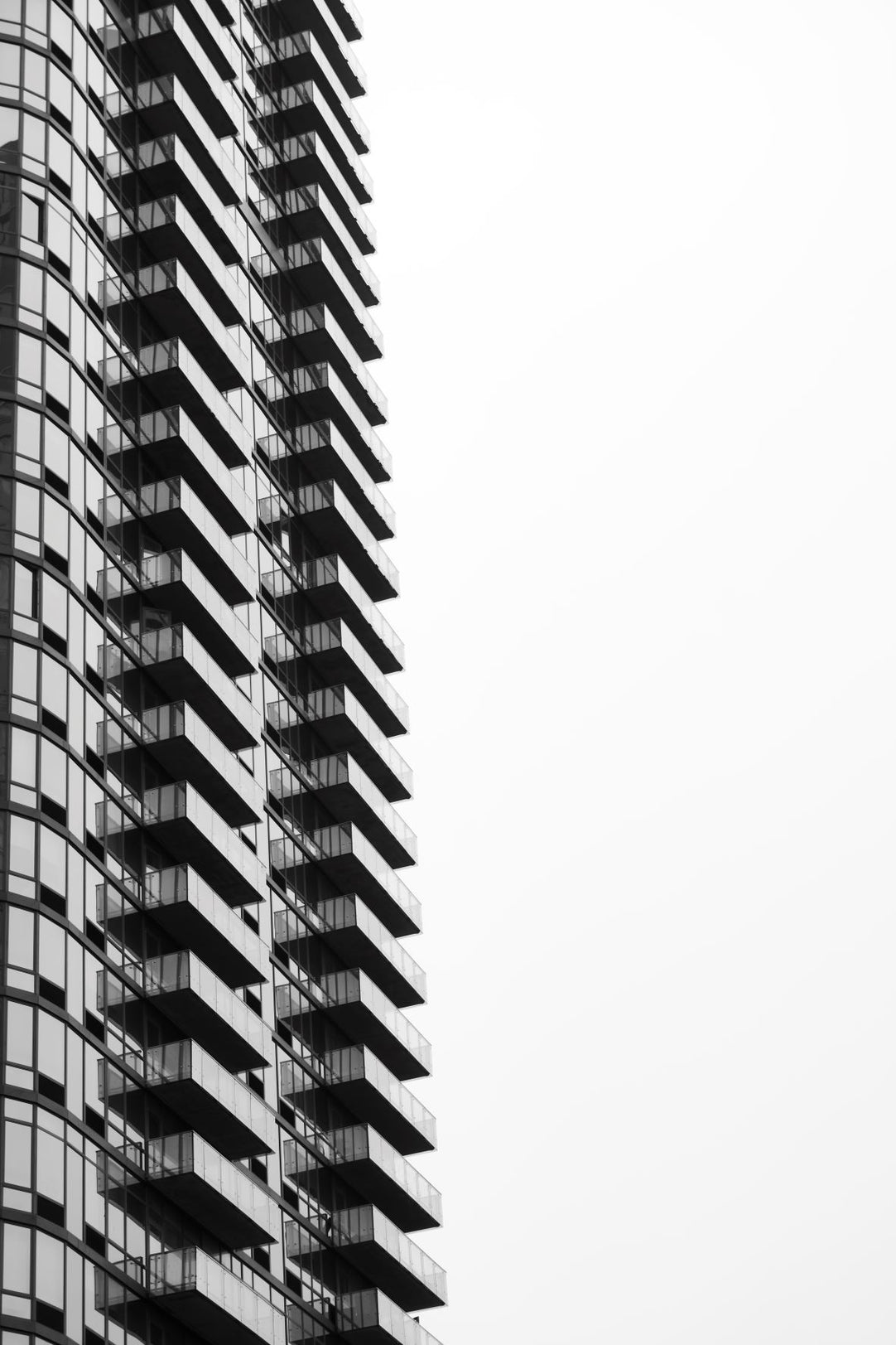 Black and white photo of a tall building with balconies