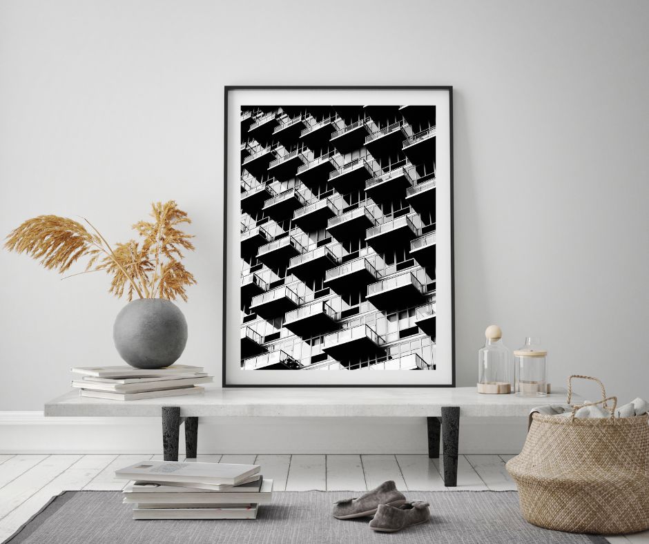 Framed black and white abstract art print on a wall in a modern living room.