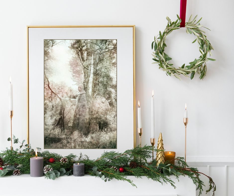 Decorative setup with framed artwork, candles, and a wreath on a white wall.