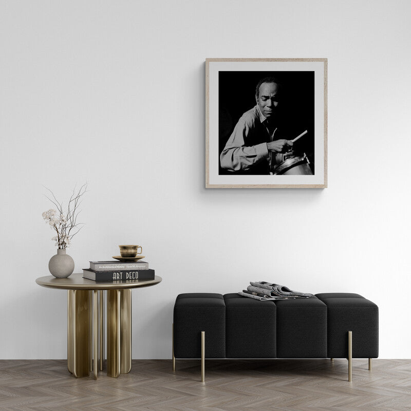 Framed black and white portrait above a modern living room setup with a sofa and side table.