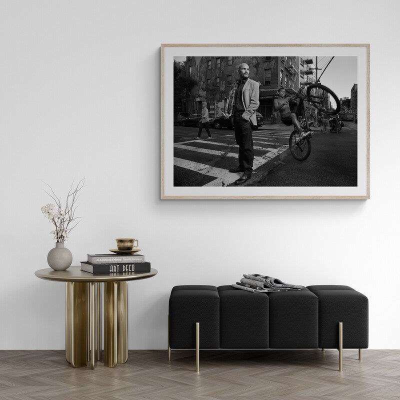 Framed black and white photograph of a city street scene above a modern living room setup.