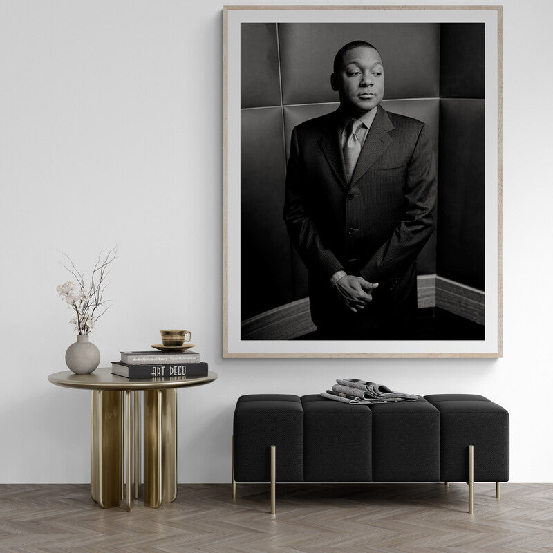 Framed black and white portrait of a man in a suit above a modern living room setup.