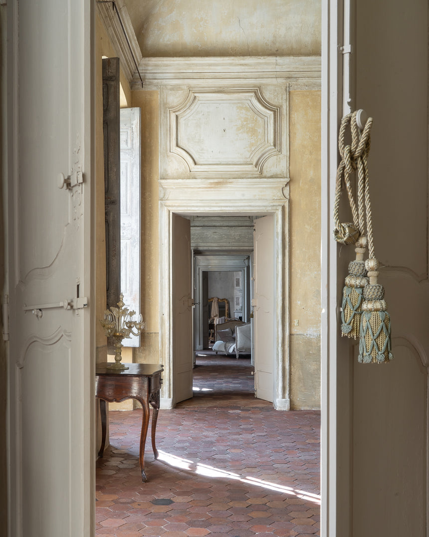 Decorative interior of an old French castle with a view through a doorway.