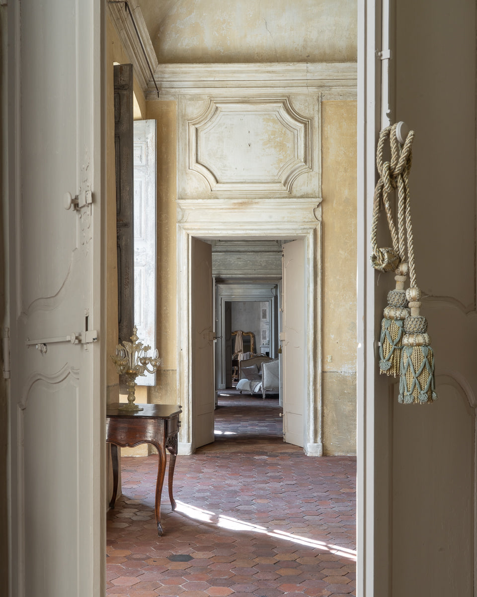 Decorative interior of an old French castle with a view through a doorway.