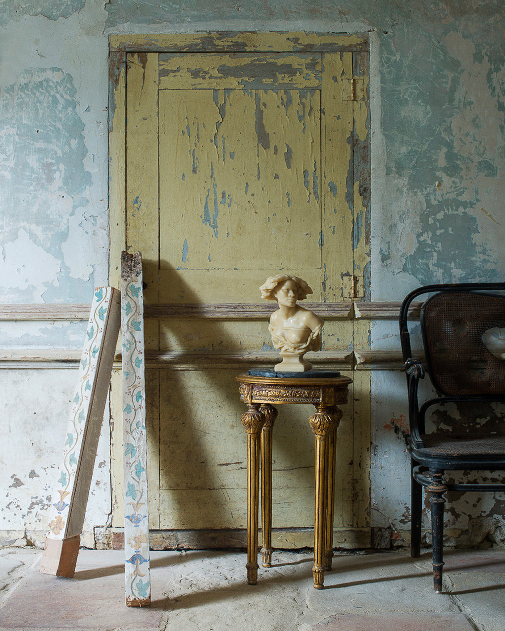 Vintage interior with a yellow door, small table, and decorative elements.