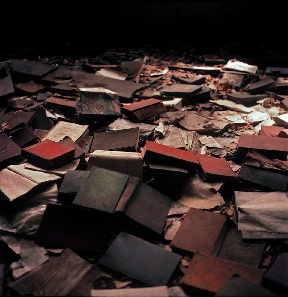 Pile of old books on the ground in a dark room