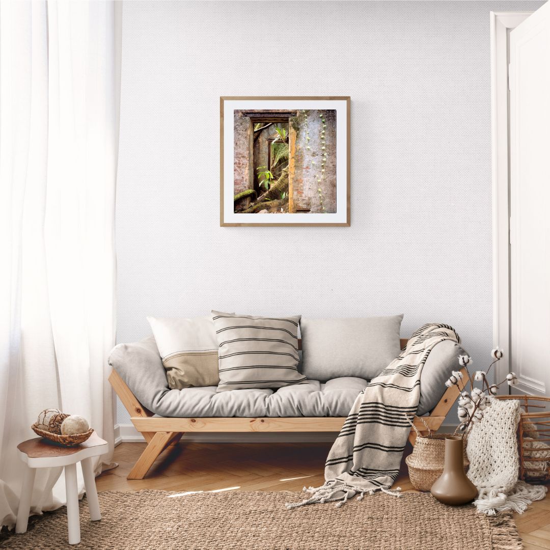 Living room with a wooden sofa, cushions, and a framed picture on the wall.