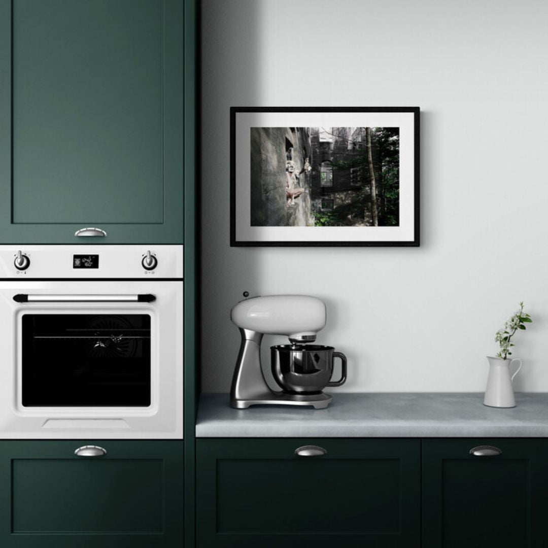 Kitchen with green cabinets, white appliances, and a framed picture on the wall.