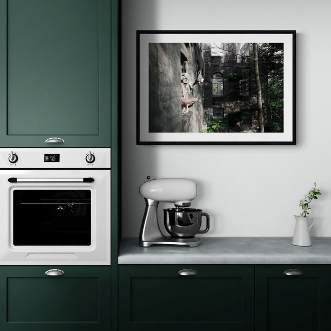 Kitchen interior with green cabinets, white appliances, and a framed picture on the wall.