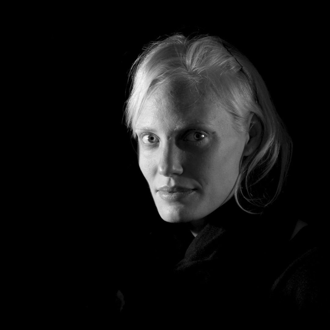 Black and white portrait of a person with light hair against a dark background