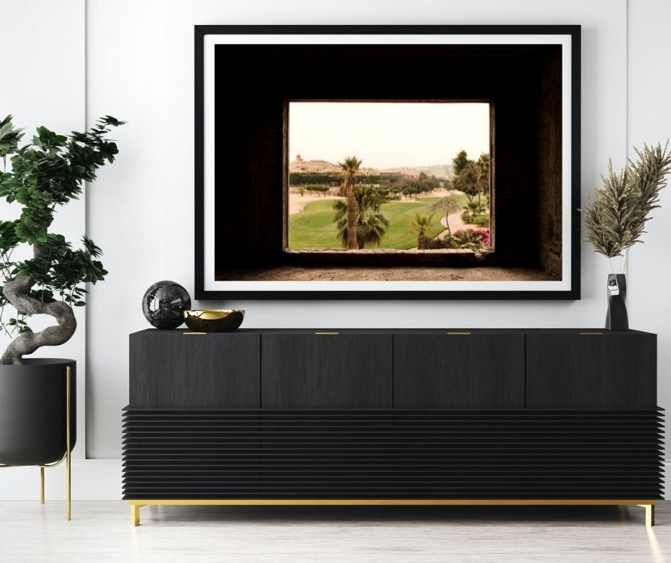 Modern interior with a black framed artwork above a black console table.
