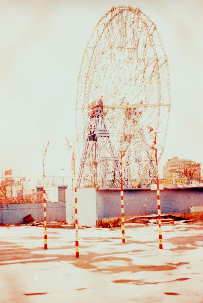 Ferris wheel structure with a city skyline in the background.