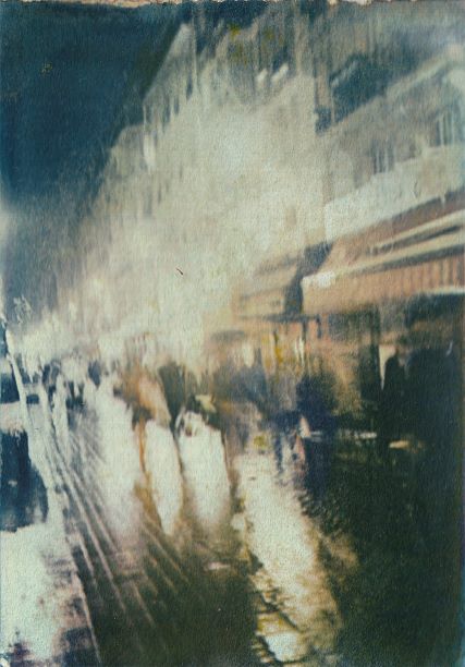 Abstract art with blurred shapes and colors of an avenue in Paris under the rain at night