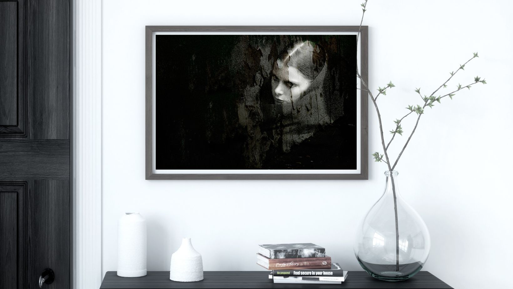 Framed black and white portrait on a wall above a shelf with decorative items.
