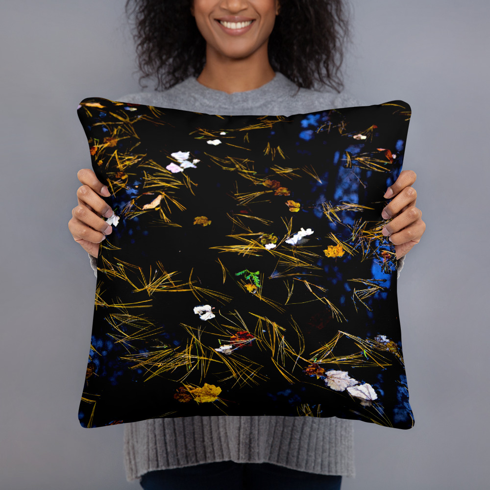 Woman holding a Square pillow with the photograph of a pond with petals and leaves floating on it