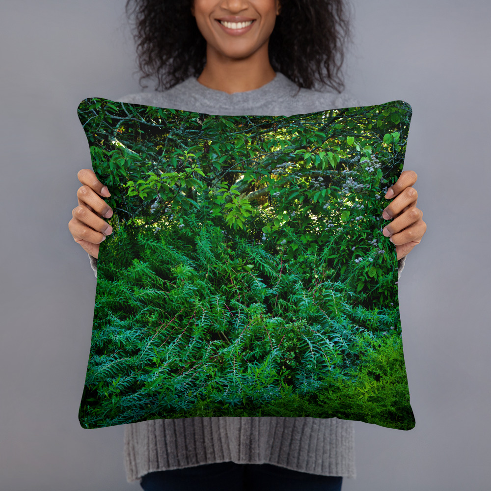 Woman holding a Square pillow with a photograph of lush greenery