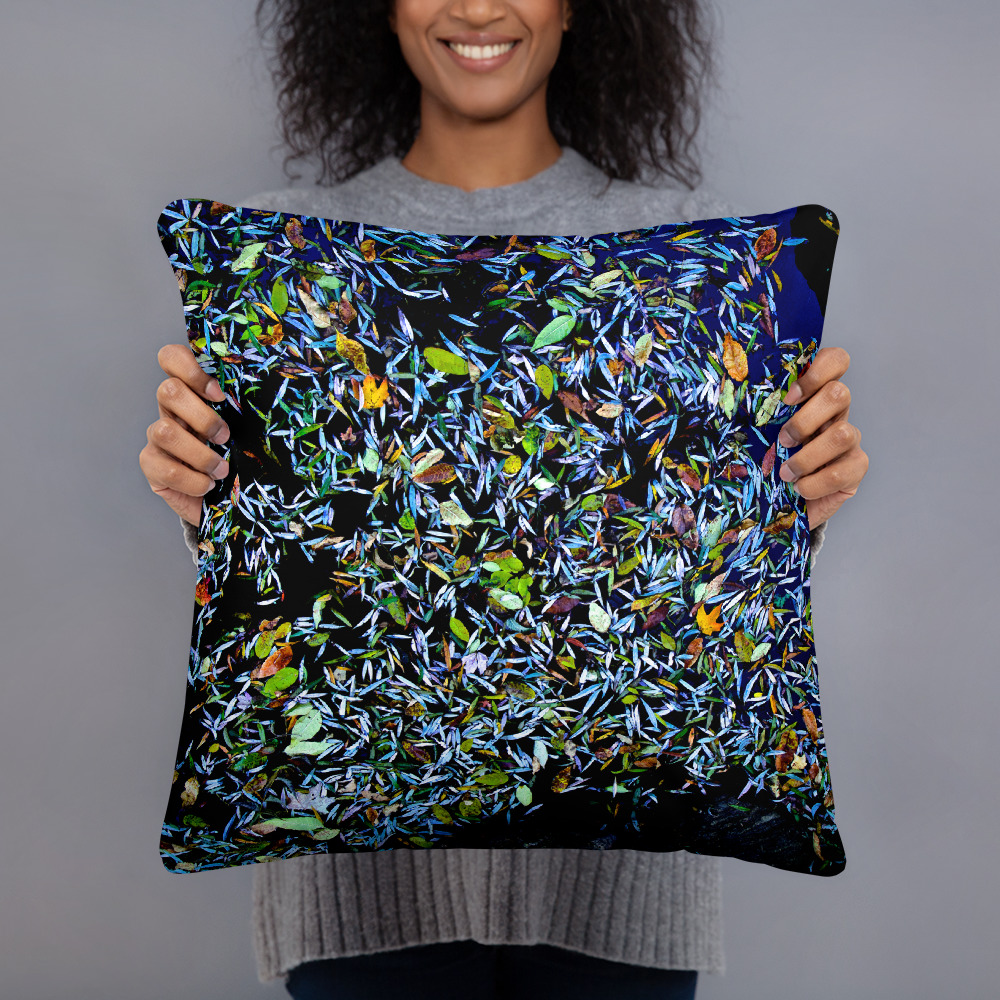 Woman holding a Square pillow with a photograph of a pond covered with flower petals