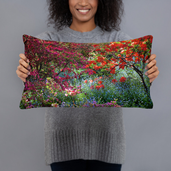 Woman holding a Rectangular pillow with the photograph of a shaded and flowery spot in a park