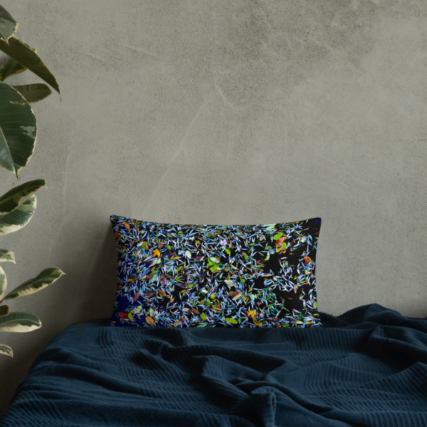 Rectangular pillow with a photograph of a pond covered with flower petals leaned against a wall