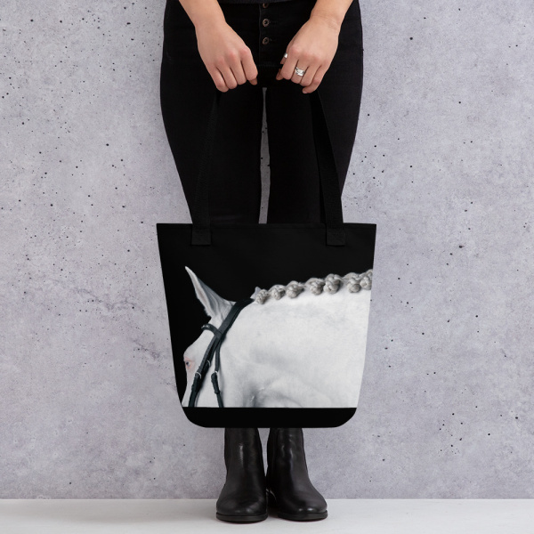 Woman holding a Black tote bag with the portrait of a white horse
