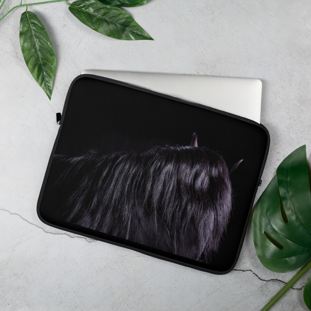 On a table, a Laptop case with a picture of the neck and hair of a black horse