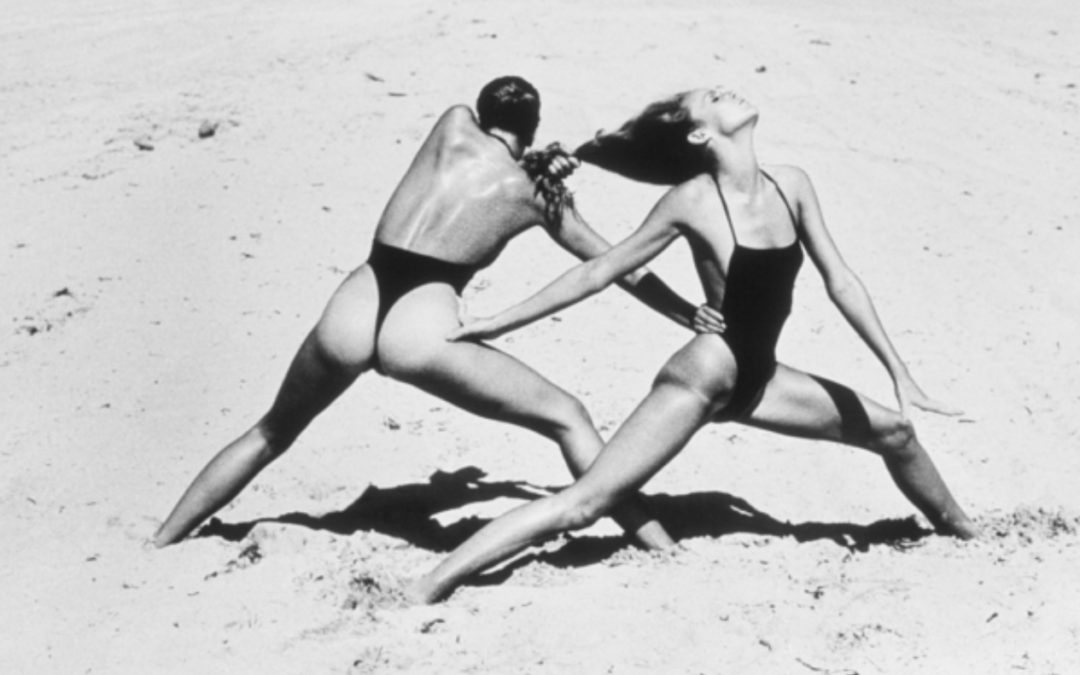 Two women in bikini pretend-fighting on a beach