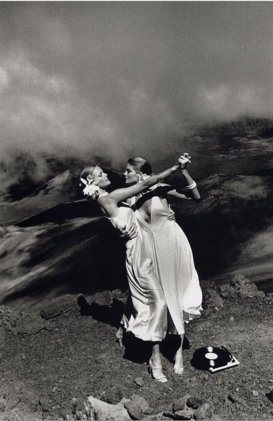 Two women dancing on top of a hill