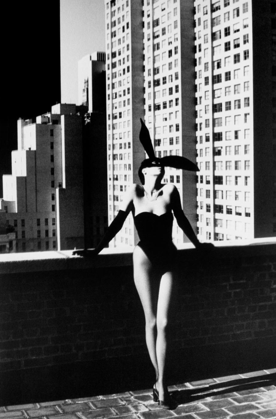 Woman in a one-piece bathing suit and bunny ears on the terrace of a building