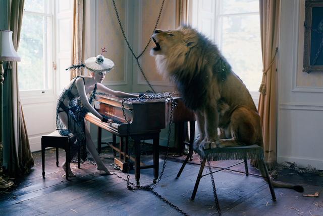 Supermodel Karen Elson in a beautiful living room, playing the piano with a lion sitting next to her