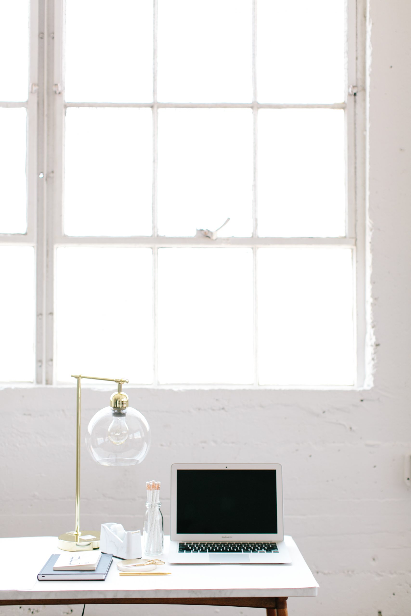 Laptop on a desk in front of a window