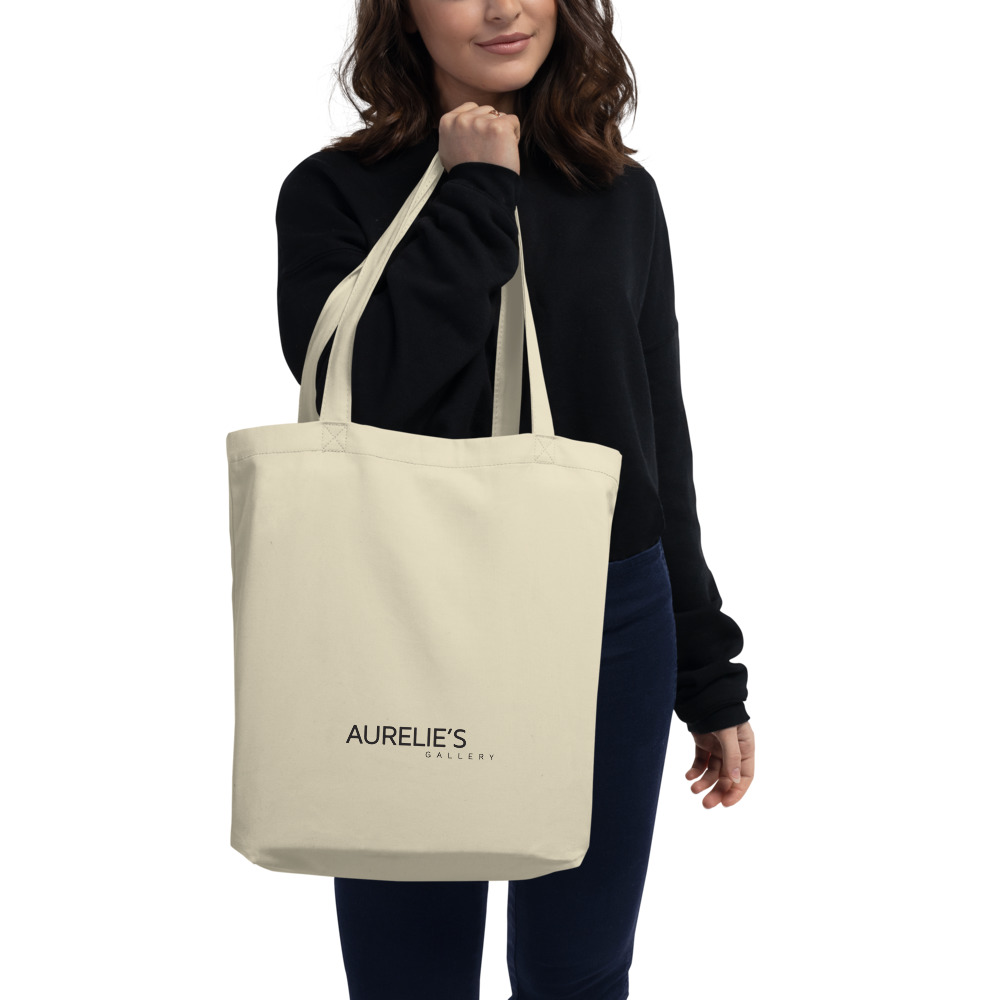 Woman holding a Medium beige tote bag with Aurelie's Gallery logo on front side
