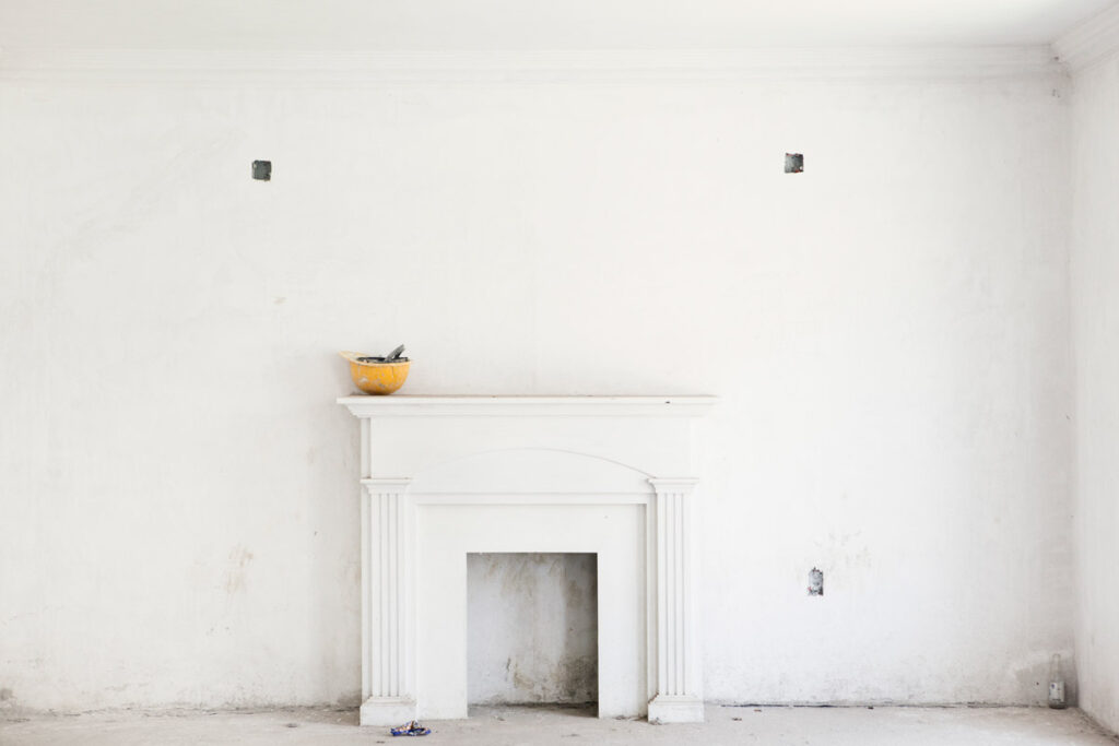 White fireplace against a wall in construction