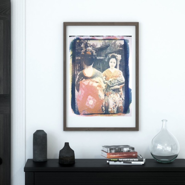 Framed print of a collage print showing two Japanese geishas in traditional kimonos, hanging above a console table