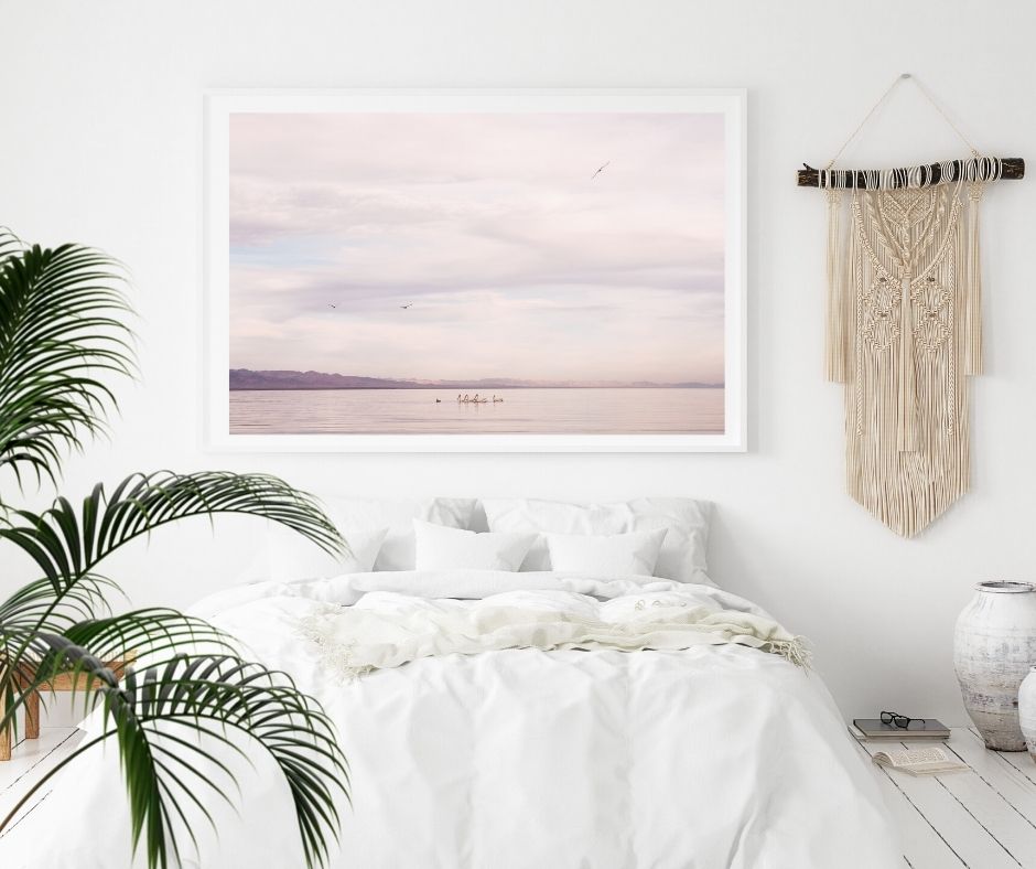 Large print of a sunset hanging above a bed