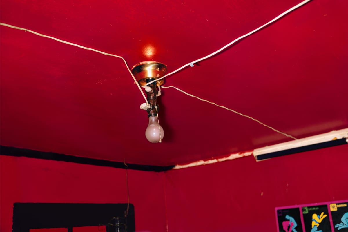 Cracked red ceiling with a bare bulb in the middle of it
