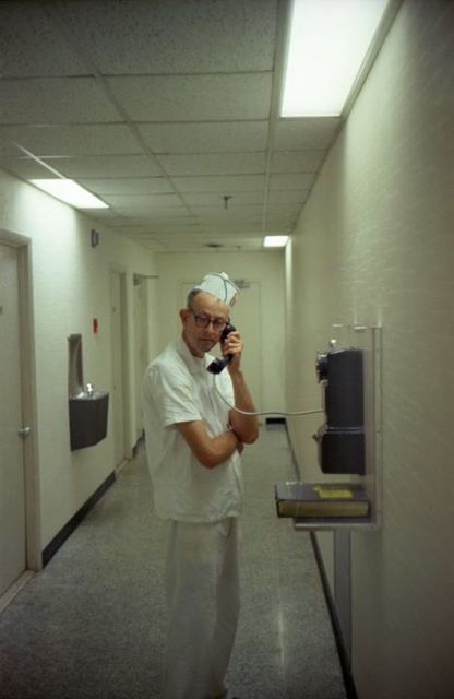 Line cook on a wall phone in a hallway